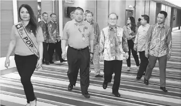  ??  ?? Uggah (second right) and Tiong (second left) make their way to the main hall for the launching. — Photo by Muhd Rais Sanusi