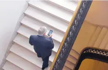  ?? SUSAN WALSH/ASSOCIATED PRESS ?? Sen. Mike Enzi, R-Wyo., checks his phone as he arrives for a lunch in the Kennedy Caucus Room on Capitol Hill in 2015. Recent reports say senators’ personal email accounts have been hacked.