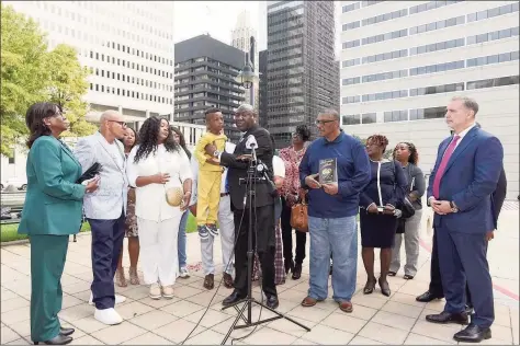  ?? Steve Ruark/Associated Press ?? Attorney Ben Crump, center, holds Zayden Joseph, 6, the great-grandson of Henrietta Lacks, while standing with attorneys and other descendant­s of Lacks, whose cells have been used in medical research without her permission.