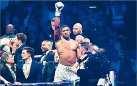  ?? Dan Mullan Getty Images ?? HEAVYWEIGH­T CHAMPION Anthony Joshua basks in the spotlight after defeating Wladimir Klitschko by 11th-round technical knockout in England.
