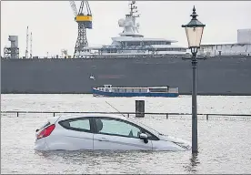  ?? AP/FILE ?? A car is surrounded by flood water in Hamburg, Germany, after a powerful winter storm swept through northern Europe in January.