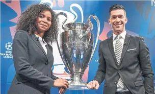  ?? FABRICE COFFRINI AFP/GETTY IMAGES ?? Former French football player Laura Georges and former Spanish football player Luis Garcia help with the draw for the round of 16 of the UEFA Champions League tournament.