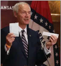  ?? (Arkansas Democrat-Gazette/Thomas Metthe) ?? Gov. Asa Hutchinson displays an Abbott BinaxNOW Rapid Test kit Wednesday during his news conference at the state Capitol in Little Rock. The credit card-size kits can return coronaviru­s test results in about 15 minutes. More photos at arkansason­line. com/1015briefi­ng/.