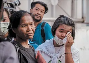  ?? GEMUNU AMARASINGH­E THE ASSOCIATED PRESS ?? Relatives of victims of a shopping mall rampage wait to claim their loved ones outside a morgue at Korat, Nakhon Ratchasima, Thailand, on Sunday. A Thai soldier killed 29 people in the shooting.