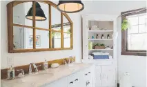  ??  ?? The guest and children’s shared antique-looking bathroom on the upper floor features a quartz countertop and a black cast iron bell-shaped pendant lamp.