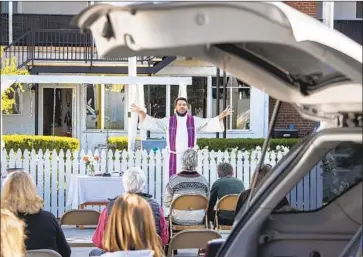  ?? Brian van der Brug Los Angeles Times ?? THE REV. MORGAN BERG leads a celebratio­n of St. Lucia’s Day in the parking lot of Norwegian Seamen’s Church in San Pedro. The saint is a 4th century Sicilian girl martyred for her Christian faith.