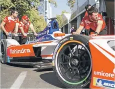  ??  ?? ► Los mecánicos e ingenieros del equipo Mahindra afinan los últimos detalles de sus monoplazas mientras los pilotos ensayan el cambio de auto en pits.