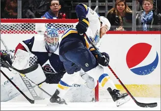  ??  ?? Colorado Avalanche goaltender Semyon Varlamov, back, looks to block a redirected shot off the stick of St. LouisBlues center Ryan O’Reilly in the first period of an NHL hockey game on Feb 16, in Denver. (AP)