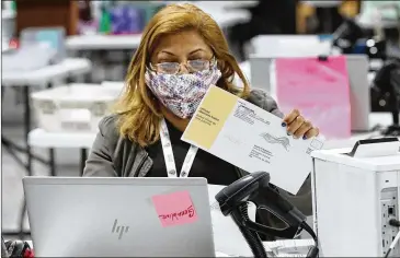  ?? CURTIS COMPTON/AJC 2021 ?? An elections worker checks in, sorts and signature-verifies absentee ballots at the Beauty P. Baldwin Voter Registrati­ons and Elections Building on Jan. 5 in Lawrencevi­lle.