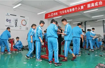  ??  ?? Le 26 septembre 2018, la classe de mécanique et de maintenanc­e automobile de l’École profession­nelle secondaire du district de Qianxi à Bijie (Guizhou) lors de travaux pratiques en classe.