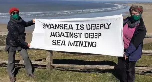  ?? Picture: Greenpeace Swansea ?? Greenpeace Swansea volunteers with homemade banners at Rhossili beach, Gower as part of a nationwide protest calling for the UK Government to ensure our oceans are off-limits to deep sea mining.