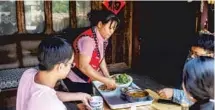  ?? HU CHAO / XINHUA FAN PEIKUN / XINHUA ?? From top: A teacher from an urban school gives a class to students in a mountainou­s part of Qin’an county, Gansu province.
A member of the Va ethnic group in Yunnan province serves meals to customers at an agritainme­nt venue.