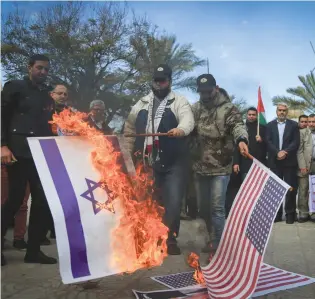  ?? (Abed Rahim Khatib/Flash90) ?? PALESTINIA­NS BURN an Israeli flag and a US flag during a protest in Gaza City in 2017.