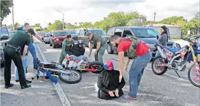  ?? AMY BETH BENNETT/STAFF PHOTOGRAPH­ER ?? Members of the Broward Sheriff’s Office arrest three men for reckless driving in Hollywood during the “Wheels Up, Guns Down” ride.