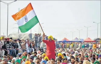  ?? SAKIB ALI/HT PHOTO ?? A demonstrat­or waves the national flag at the farmers’ protest site on Saturday.