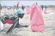  ?? SAM MEDNICK — THE ASSOCIATED PRESS ?? A woman scoops fallen sorghum grain off the ground last week after the World Food Program air-dropped food in Kandak, South Sudan. The nation has been torn by a civil war, now in its fifth year, and 7million citizens face hunger.