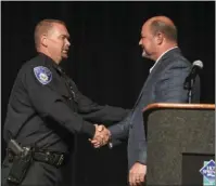  ?? The Sentinel-Record/Grace Brown ?? PINNED: Hot Springs City Manager Bill Burrough, right, shakes hands with the new Hot Springs police chief, Chris Chapmond, after a pinning ceremony Thursday in Horner Hall at the Hot Springs Convention Center.