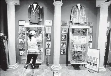  ??                                                                 ?? Lauren McBride, girlfriend of Jerry “The King” Lawler, helps install photos and memorabili­a from the wrestling legend’s career                                                                                                                              ...