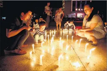  ?? Wu Hong
European Pressphoto Agency ?? RESIDENTS IN JIANLI, China, light candles for those missing or dead after a tourist ship capsized with 458 people aboard. Only 14 people are known to have survived, and 102 had been confirmed dead.