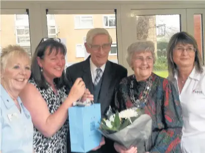  ??  ?? Eric Greaves with staff and residents receiving gifts at his retirement party held at Connell Court care home in Southport where he has volunteere­d for 26 years