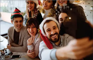  ??  ?? SELFIE AWARE: Social media has brought added peril to festive frolics at the office Christmas party.