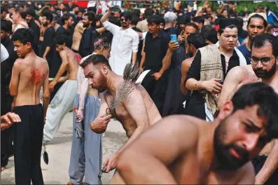  ?? (AP/Anjum Naveed) ?? Shiite Muslims flagellate themselves with knives on chains Monday during a Muharram procession in Islamabad, Pakistan. Muharram, the first month of the Islamic calendar, is a month of mourning for Shiites in remembranc­e of the death of Hussein, the grandson of the Prophet Muhammad, at the Battle of Karbala in present-day Iraq in the 7th century.