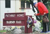  ?? JOSH EDELSON / AP ?? Resident Tom Parkinson places flowers on a sign at the Veterans Home of California facility on Saturday.