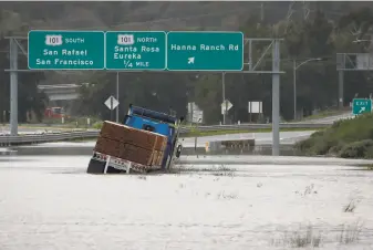  ?? Paul Chinn / The Chronicle 2019 ?? A big rig hauling lumber is trapped in floodwater on Highway 37 after heavy rainstorms in February 2019 closed the segment between Highway 101 and Atherton Avenue in Novato.