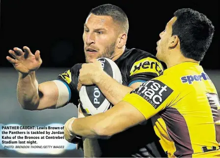  ?? PHOTO: BRENDON THORNE/GETTY IMAGES ?? PANTHER CAUGHT: Lewis Brown of the Panthers is tackled by Jordan Kahu of the Broncos at Centrebet Stadium last night.