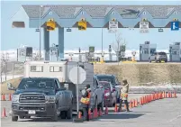  ?? ANDREW VAUGHAN THE CANADIAN PRESS FILE PHOTO ?? Health Department workers stop traffic that has crossed the Confederat­ion Bridge in P.E.I. in March. P.E.I. has only had 27 coronaviru­s cases and the last sufferer recovered weeks ago.