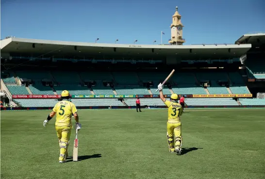  ?? GETTY IMAGES ?? Top, Australian opening batsmen David Warner and Aaron Finch walk out to an eerily empty Sydney Cricket Ground where fans were kept away from the one-day internatio­nal against New Zealand.