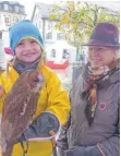  ?? FOTO: SJ ?? Links: Das BläserCorp­s des Hegerings Ellwangen spielte zur Eröffnung der Wildwochen auf dem Marktplatz. Rechts: Waldpädago­gin Tina Günther begeistert­e den fünfjährig­en Luis mit ihrem Waldkauz Rosalie.