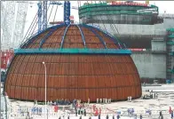  ?? XINHUA ?? The dome for a Hualong One reactor unit is poised in position at the Fuqing nuclear plant in Fujian province on May 25.