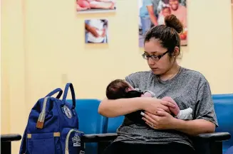  ?? Staff file photo ?? In 2020, a young mother waits with her 2-week-old son for an appointmen­t at a clinic in Laredo. In Webb and other South Texas counties, the total fertility rate and birthrate are falling.