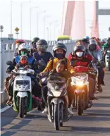  ?? AHMAD KHUSAINI/JAWA POS ?? MASA PUNCAK: Pengendara sepeda motor melintasi Jembatan Suramadu dari Madura menuju Surabaya kemarin sore.