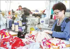  ?? PHOTOS BY NIU JING / FOR CHINA DAILY ?? An employee puts finishing touches to swimsuits at a factory in Huludao city in Liaoning province.