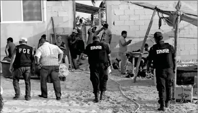  ??  ?? Policías estatales toman conocimien­to del asalto a mano armada ocurrido la tarde de ayer en una bodega pepinera en Las Coloradas, Tizimín