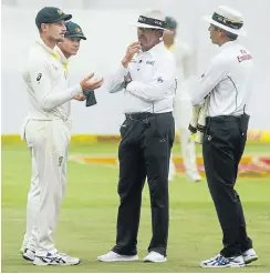  ?? Picture: AFP and Gallo Images ?? Umpires Nigel Long and Richard Illingwort­h confront Australia's Cameron Bancroft during day three of the third Sunfoil test match between South Africa and Australia at PPC Newlands in Cape Town yesterday.