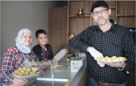  ?? DAX MELMER ?? Syrian refugees Mohamad Amer Haboub, Hanadi Almaraiati and their 12-year-old son Abdul prepare sweets at their bakery on Wyandotte Street East, a “business for family,” said Haboub, who is upgrading his English so he can use his computer programmin­g...