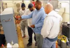  ?? THE ASSOCIATED PRESS ?? Air Conditioni­ng, Heating and Refrigerat­ion technology students, from left, Micahel Jennings, David Ellerby, Terry Foy and Roger Saunders, use a simulator in the classroom at the Cape Fear Community College downtown campus in Wilmington, N.C., The...