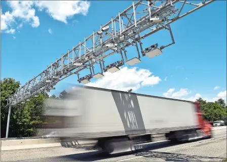  ?? TIM MARTIN/THE DAY ?? A tractor-trailer passes under a truck toll gantry between exits 2 and 3 along Interstate 95 northbound in Hopkinton, R.I., on Thursday.