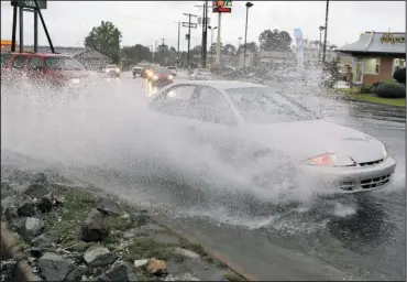  ?? The Sentinel-Record/Richard Rasmussen ?? MAKING A SPLASH: A motorist hits a pool of water at the intersecti­on of Mountain Pine and Albert Pike roads during heavy downpours Wednesday.