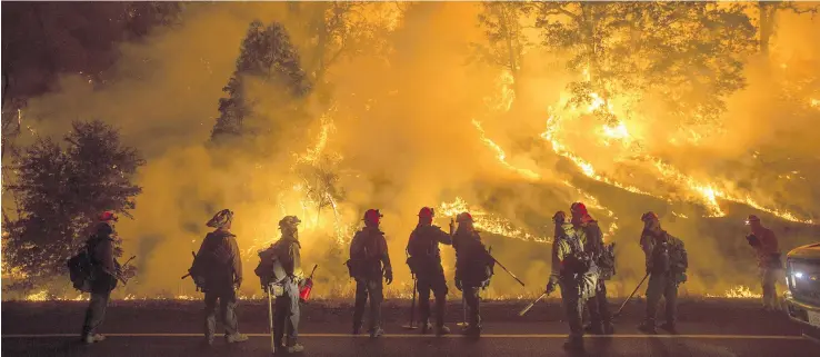  ??  ?? Flames from the Valley Fire cover a hillside along Highway 29 in Lower Lake, California on September 13. The swiftly spreading wildfire destroyed hundreds of homes and forced thousands of residents to flee as it roared unchecked through the northern...