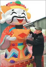  ?? SUN RUISHENG / CHINA DAILY ?? Guo Erniu with the lantern of the God of Fortune, a major product of his company this year, at his studio in Taiyuan, Shanxi province.