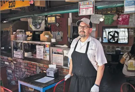  ?? James Bernal For Reveal and The Times ?? EDWARD FLORES owns Juanita’s Cafe, an eatery opened by his grandmothe­r on historic Olvera Street in downtown L.A. As sales plummeted, Flores cut his operating hours and laid off his staff. In the mostly Latino area, only 21% of businesses got PPP loans last year.