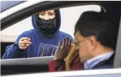  ?? DAVID DERMER AP ?? Health department worker Kathy Johnson distribute­s at-home COVID-19 test kits in Youngstown, Ohio.