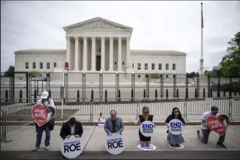  ?? Drew Angerer / Getty Images ?? Led by Rev. Patrick Mahoney, a small group of anti-abortion activists kneel and pray in front of the U.S. Supreme Court on Wednesday in Washington, DC.