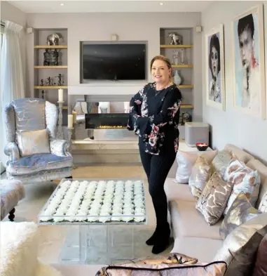  ??  ?? Norah in her living area with some of her favourite pieces, including the perspex coffee table embedded with white roses. She also loves the upholstere­d chair covered in copper-embossed velvet by textile designer Aoife Mullane