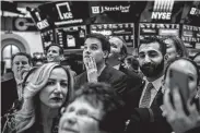  ?? Hilary Swift / New York Times ?? People gather on the floor of the New York Stock Exchange before the closing bell Tuesday. Gains for 2018 were erased as a sell-off continued.