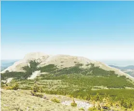  ?? PHOTOS: MOUNTAIN LEGACY PROJECT ?? A 1913 photo shows vast areas of this peak in the Rocky Mountains without vegetation. The same peak in 2006 shows how trees are spreading upward.